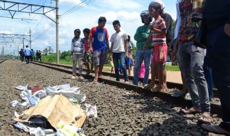 Warga menyaksikan jasad korban tewas di Stasiun Kereta Api Klender Baru, Pondok Kopi, Jakarta Timur, Jumat (29/3).