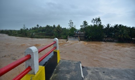 Warga menyaksikan Jembatan Pesangrahan yang ambruk diterjang banjir bandang sungai Cipatujah, Kabupaten Tasikmalaya, Jawa Barat, Rabu (7/10/2018).