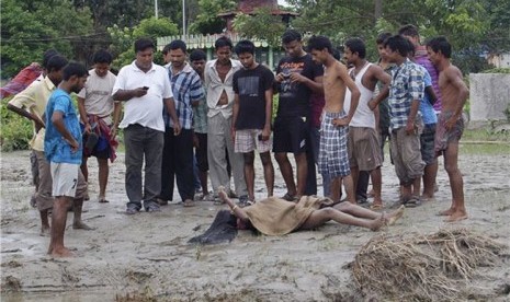 Warga menyaksikan jenazah korban kerusuhan etnis di dekat Kota Kokorajhar, negara bagian Assam, India, pada Sabtu (21/7).