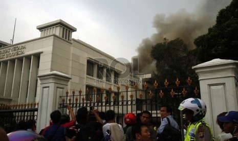   Warga menyaksikan kepulan asap tebal yang melanda Gedung Sekretariat Negara di Komplek Istana Negara, Jakarta, Kamis (21/3) sore.  (Republika/Adhi Wicaksono)