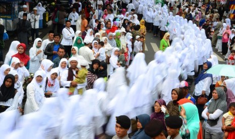 Warga menyaksikan kirab santri guna menyambut Hari Santri Nasional ke-2 di Tasikmalaya, Jawa Barat, Kamis (20/10). 