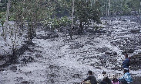 Warga menyaksikan lahar dingin yang mengalir di Sungai Yeh Sah, Rendang, Karangasem, Bali, Sabtu (2/12). Hujan deras di kawasan Gunung Agung menyebabkan lahar dingin kembali mengalir di sungai itu. 