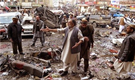 Warga menyaksikan lokasi yang hancur akibat serangan bom di Quetta, Balauchistan, Pakistan.