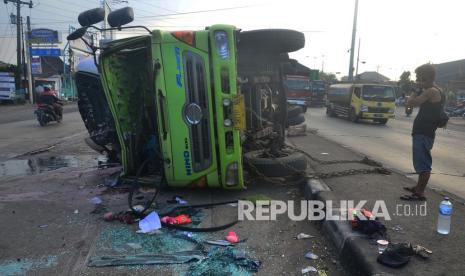 Warga menyaksikan mobil truk yang mengalami kecelakaan di jalan jalur pantura Desa Tanjungkarang, Jati, Kudus, Jawa Tengah, Senin (14/3/2022). Kecelakaan truk bernopol B 9010 NEN pengangkut buah yang menabrak mobil pribadi bernopol B 2760 UFJ tersebut disebabkan sopir truk menghindari pesepeda yang menyeberang saat lampu lalu lintas menyala merah dan menyebakan seorang sopir mengalami luka ringan. 