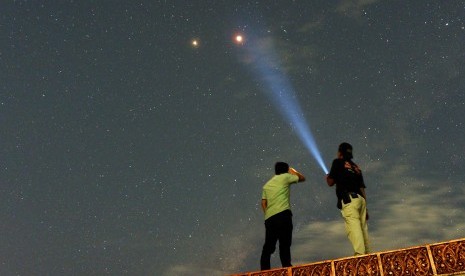 Warga menyaksikan pemandangan planet Mars berdampingan dengan gerhana bulan total terlihat di Kota Padang, Sumatera Barat, Sabtu (28/7) dini hari.