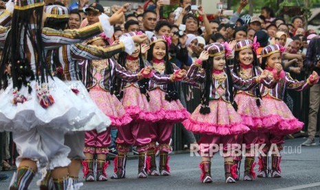 Warga menyaksikan penampilan peserta dari negara Uzbekistan pada parade lintas budaya di Jalan Tunjungan Surabaya, Jawa Timur, Ahad (15/7). 