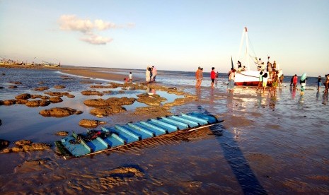 Warga menyaksikan perahu Arim Jaya yang karam di Pantai Desa Romben Barat, Dungkek, Sumenep, Jawa Timur, Selasa (18/6/2019). 