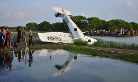 Warga menyaksikan pesawat yang mengalami kecelakaan di area Tambak Nggojoyo, Desa Wedung, Demak, Jawa Tengah, Senin (20/6). Pesawat terbang latih jenis CESNA 172 PK-NIV milik sekolah penerbangan PT Nusa Fliying Internasional (NFI) tersebut mengalami kecela