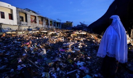 Warga menyaksikan puing bangunan pasar Meuredu yang rubuh akibat gempa di Pidie Jaya, Aceh, Kamis (8/12). Hingga hari kedua pasca gempa bumi, tim Basarnas dibantu aparat TNI/Polri dan para relawan masih melakukan upaya pencarian serta evakuasi korban yang 