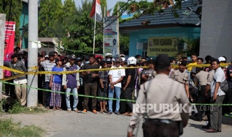 Warga menyaksikan saat petugas kepolisian melakukan olah TKP di lokasi pasca ledakan di pabrik produksi kembang api, Jalan Salembaran, Desa Belimbing, Kecamatan Kosambi Kabupaten Tangerang, Banten, Jumat (27/10).