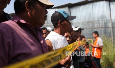 Warga menyaksikan saat petugas kepolisian melakukan olah TKP di lokasi pasca ledakan di pabrik produksi kembang api, Jalan Salembaran, Desa Belimbing, Kecamatan Kosambi Kabupaten Tangerang, Banten, Jumat (27/10).