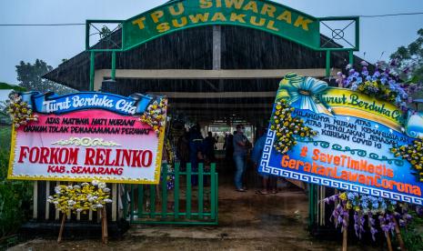 Warga menyaksikan sejumlah karangan bunga berisi protes kepada oknum warga penolak pemakaman jenazah di Tempat Pemakaman Umum (TPU) Siwarak Suwakul, Kelurahan Bandarjo, Ungaran Barat, Kabupaten Semarang, Jawa Tengah, Ahad(12/4/2020). Puluhan karangan bunga dari Persatuan Perawat Nasional Indonesia dan masyarakat itu mengecam sejumlah oknum warga setempat yang menolak pemakaman seorang perawat RSUP dr Kariadi Semarang yang meninggal dunia akibat COVID-19 pada Kamis (9/4/2020) lalu di TPU tersebut. 