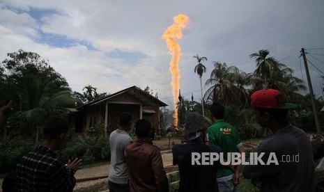 Warga menyaksikan semburan api di lokasi pengeboran minyak (ilustrasi).