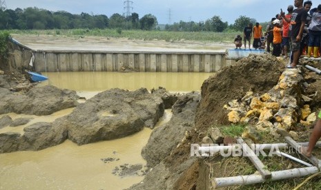 Warga menyaksikan tanggul bendungan Gelapan yang jebol di Desa Gelapan, Gubug, Grobogan, Jawa Tengah, Kamis (9/1/2020).