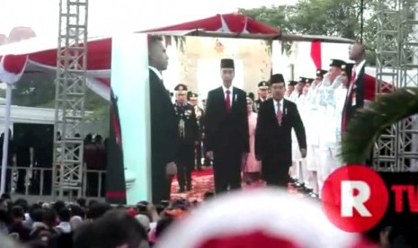 Warga menyaksikan upacara kemerdekaan Republik Indonesia melalui layar besar di sekitar Istana Negara Jakarta.