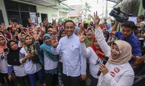 Warga menyambut kedatangan Calon Gubernur DKI Jakarta Anies Baswedan saat melakukan kampanye di kawasan Kebon Jeruk, Jakarta, Selasa (17/1). 