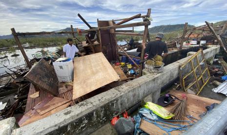 Warga menyelamatkan barang-barang yang tersisa di rumah mereka yang rusak akibat Topan Rai di kota Surigao, Surigao del Norte, Filipina tengah, Jumat 17 Desember 2021.