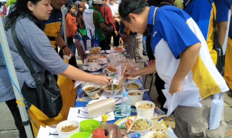 Warga menyerbu mi ayam seharga Rp 5.000 di acara Fetival MIe Bogasari 2019 yang berlangsung di Stadion Pakansaroi, Cibinong, Bogor, Ahad (21/4)