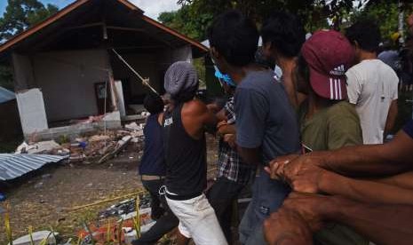 Warga merobohkan rumah yang rusak akibat gempa bumi di Kayangan, Lombok Utara, NTB, Minggu (12/8).