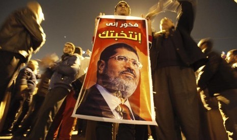 Warga Mesir pendukung Presiden Muhammad Mursi memberikan dukungannya dalam aksi unjuk rasa di Rabaa El Adaweya di Kairo, Ahad (9/12). (Reuters/Amr Abdallah Dalsh)  