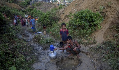 Warga Muslim Rohingya, yang menyeberang dari Myanmar ke Bangladesh, mengumpulkan air hujan di kamp pengungsi Balukhali, Bangladesh, Rabu (13/9). 