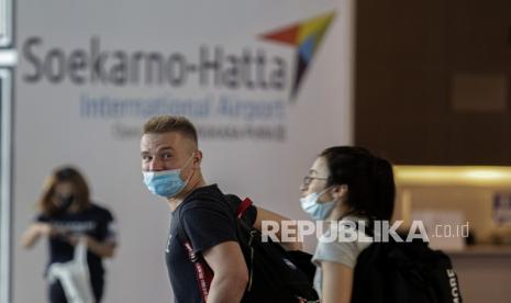 Warga Negara Asing (WNA) berjalan di area kedatangan internasional setibanya di Terminal 3 Bandara Internasional Soekarno-Hatta, Tangerang, Banten, Senin (29/11/2021). Pemerintah memberlakukan larangan WNA dari Afrika Selatan, Botswana, Namibia, Zimbabwe, Lesotho, Mozambique, Eswatini, Malawi, Angola, Zambia dan Hongkong untuk masuk ke wilayah Indonesia guna mencegah masuknya varian COVID-19 B.1.1.529 atau Omicron dan mewajibkan karantina selama 14 hari bagi penumpang yang berkunjung dari negara tersebut, sedangkan penumpang dari selain negara tersebut wajib karantina selama tujuh hari. 