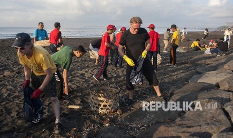 Warga negara Australia bersama masyarakat Bali memungut sampah plastik yang berserakan di Pantai Biaung, Denpasar, Bali, Sabtu (2/6).