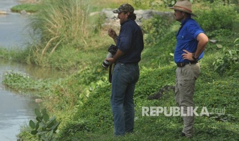 Warga negara Australia, Matthew Nicolas Wright (kiri) dan Chris Wilson (kanan) memantau lokasi kemunculan seekor buaya liar yang terjerat ban sepeda motor di Sungai Palu di Palu, Sulawesi Tengah, Selasa (11/2/2020).