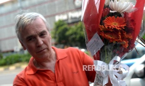 Warga negara Inggris Neil Whitcombe (63 tahun) membawa karangan bunga diletakkan di lokasi ledakan Pos Polisi Sarinah, Jakarta, Jumat (15/1). 