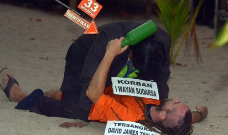 Warga negara Inggris yang juga tersangka pembunuhan polisi, David James Taylor, berkelahi dengan pemeran korban Aipda Wayan Sudarsa saat rekonstruksi di Pantai Legian, Bali, Rabu (31/8).