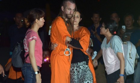 Warga negara Inggris yang juga tersangka pembunuhan polisi, David James Taylor (dua kiri) berpelukan dengan pacarnya warga negara Australia Sara Connor saat rekonstruksi di Pantai Legian, Bali, Rabu (31/8).