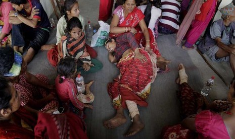  Warga Nepal yang terluka akibat gempa bumi menunggu dievakuasi di Trishul Bazar, Nepal, Senin (27/4). 