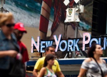 Warga New York beraktifitas di bawah kamera pengintai NYPD di Times Square, New York.