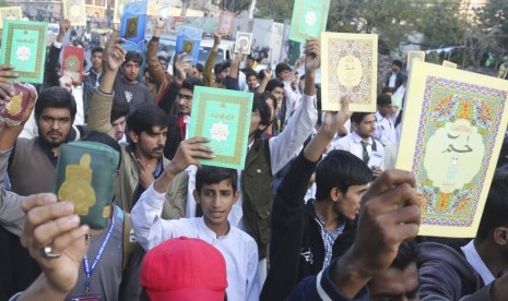 Warga Pakistan mengangkat tinggi Alquran di kepala dalam aksi protes di Lahore, Pakistan, Sabtu (23/11). Warga memprotes aksi bakar Alquran yang dilakukan oleh demonstran anti-Islam pekan lalu.