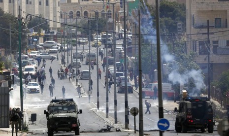 Warga Palestina bentrok dengan pasukan Israel setelah protes terhadap pembukaan kedutaan AS di Yerusalem, di kota Betlehem, Tepi Barat, Senin, 14 Mei 2018.