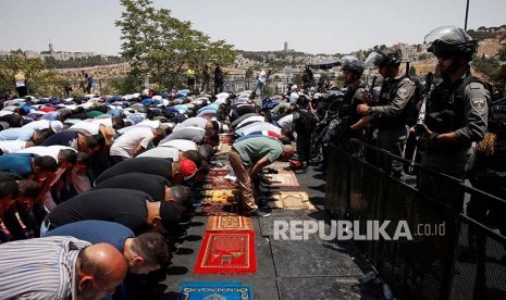 Pasukan Israel menjaga warga Palestina yang shalat dengan senjata. (ilustrasi).