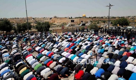 Warga Palestina melaksanakan Shalat Jumat di jalan menuju kompleks Masjid Aqsha yang diblokir polisi Israel di Kota Tua Yerusalem, Jumat (21/7)