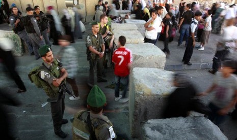 Warga Palestina melewati sebuah pos pemeriksaan tentara Israel dalam perjalanan mereka untuk Shalat Jumat di Masjid Al-Aqsa, Yerusalem, Jumat (10/8). (Majdi Muhammad/AP)