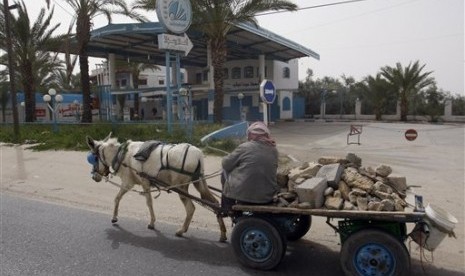  Warga Palestina melintas di Stasiun Pengisian Bahan Bakar yang tutup di kota Rafah, Selasa (20/3) lalu. (Foto : Hatem Moussa/AP)