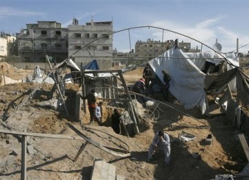  Warga Palestina membersihkan puing-puing rumah mereka yang hancur akibat terkena serangan udara Israel di perbatasan Mesir-Rafah, Jalur Gaza, Jumat (3/2). 