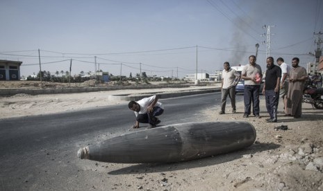  Warga Palestina mengamati bom Israel yang gagal meledak di Deir al-Balah, Gaza.