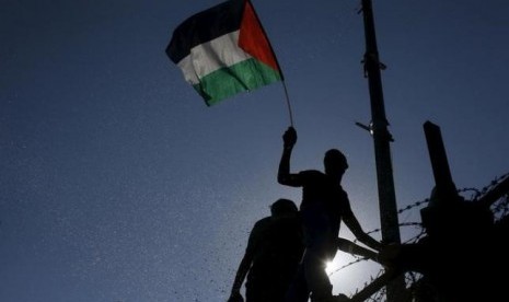 Warga Palestina mengibarkan bendera.