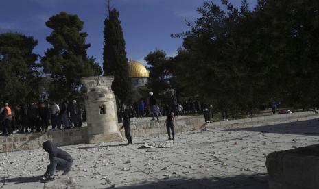 Warga Palestina mengumpulkan batu untuk dilemparkan ke polisi Israel setelah mereka memasuki kompleks Masjid Al Aqsa, di Kota Tua Yerusalem, Jumat, 22 April 2022. Polisi Israel Masuki Kompleks Masjid Al Aqsa Bersihkan Pengunjuk Rasa Palestina