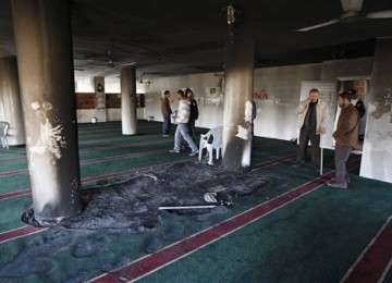 Warga Palestina menyaksikan kerusakan yang terjadi akibat pembakaran masjid di Burqa, Tepi Barat, Kamis (15/12).