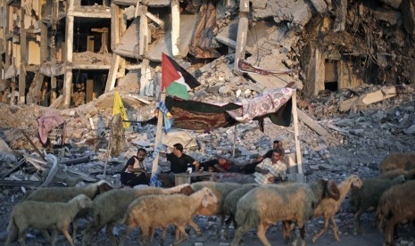 Warga Palestina sedang duduk di tempat perlindungan yang terbuat dari selimut di Gaza