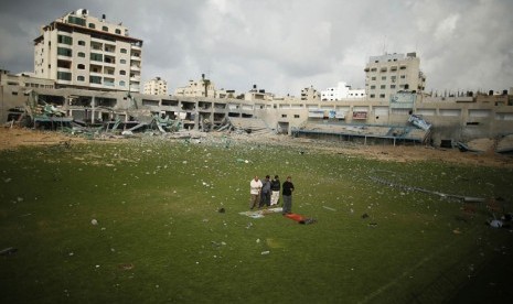 Warga Palestina shalat di tengah lapangan stadion sepak bola, yang hancur akibat serangan udara Israel selama konflik delapan hari di Kota Gaza,Selasa (4/12)/ (Reuters/Suhaib Salem)