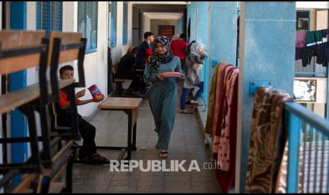 Warga Palestina yang terdiri dari perempuan dan anak-anak mengungsi untuk berlindung dari serangan udara Israel ke bangunan sekolah milik PBB di Gaza, Rabu (19/5) waktu setempat. 