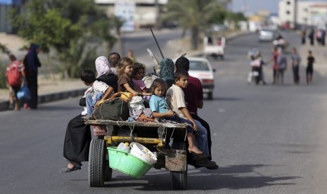 Warga Palestina yang tinggal di Gaza mengungsi menuju tempat perlindungan PBB, Ahad (13/7)