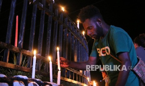 Warga Papua menyalakan lilin saat aksi damai di Bundaran Tugu Perdamaian Timika Indah, Mimika, Papua, Senin (19/8/2019). 