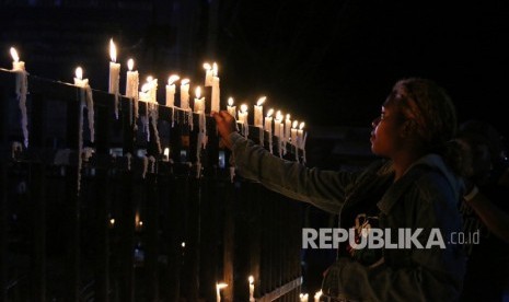 Warga Papua menyalakan lilin saat aksi damai di Bundaran Tugu Perdamaian Timika Indah, Mimika, Papua, Senin (19/8/2019).